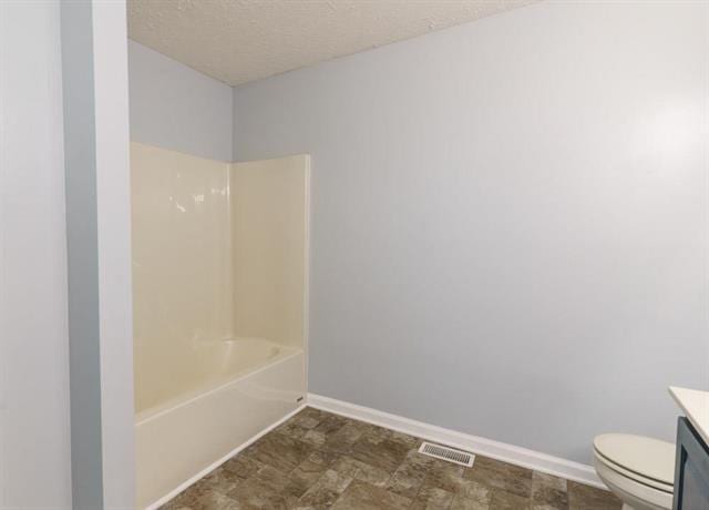 full bathroom with vanity, shower / tub combination, and toilet