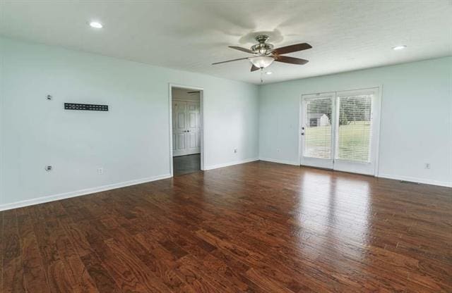 empty room with dark hardwood / wood-style floors and ceiling fan