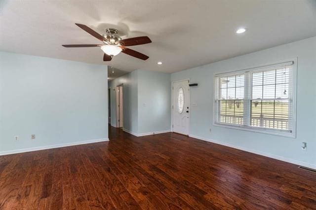 unfurnished living room with dark wood-type flooring and ceiling fan