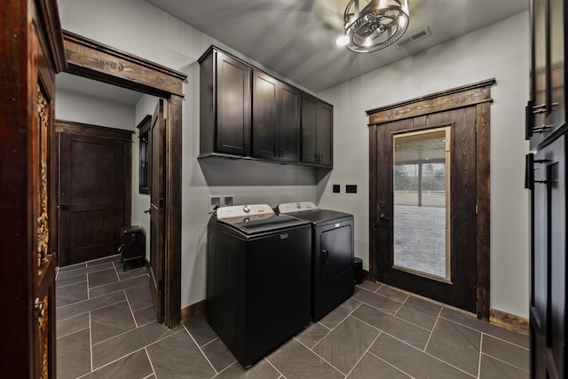 clothes washing area featuring cabinets and washing machine and clothes dryer