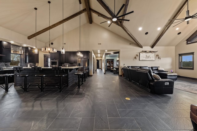 interior space featuring a kitchen bar, tasteful backsplash, stainless steel oven, pendant lighting, and ceiling fan