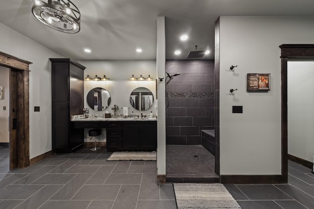 bathroom featuring a tile shower, vanity, and tile patterned flooring