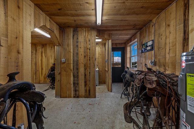 miscellaneous room featuring wooden ceiling, electric water heater, and wood walls