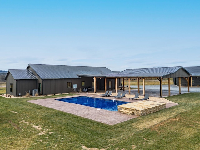 view of swimming pool with a yard, a patio area, and central air condition unit