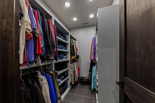 spacious closet with dark tile patterned floors