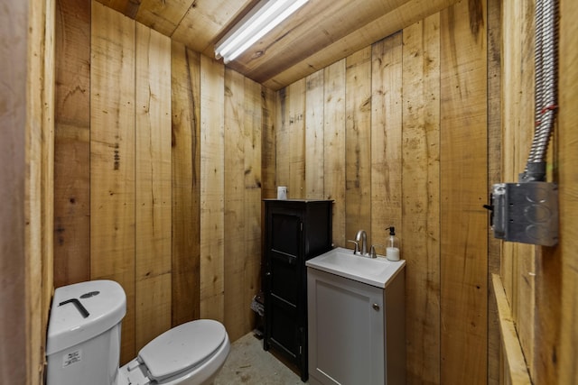 bathroom featuring vanity, toilet, wooden ceiling, and wood walls