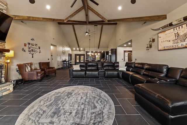 living room featuring beamed ceiling, ceiling fan, a stone fireplace, and high vaulted ceiling