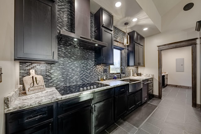 kitchen featuring black stovetop, light stone counters, hanging light fixtures, and wall chimney range hood