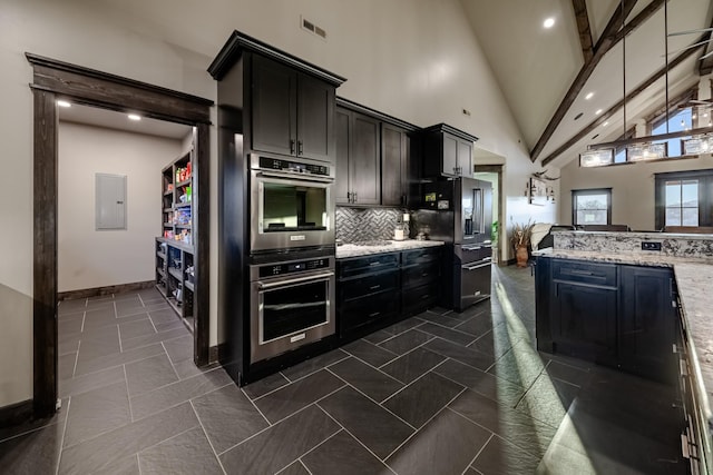 kitchen featuring appliances with stainless steel finishes, high vaulted ceiling, electric panel, tasteful backsplash, and light stone countertops