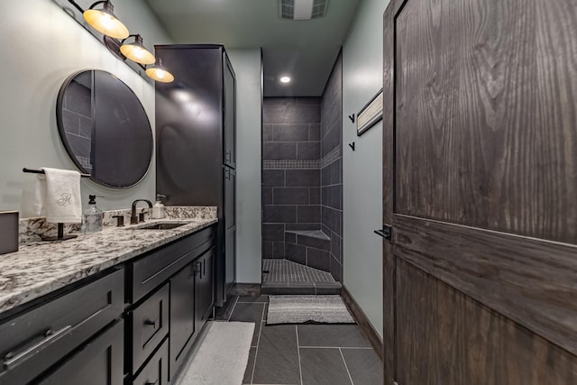 bathroom featuring tiled shower, vanity, and tile patterned floors