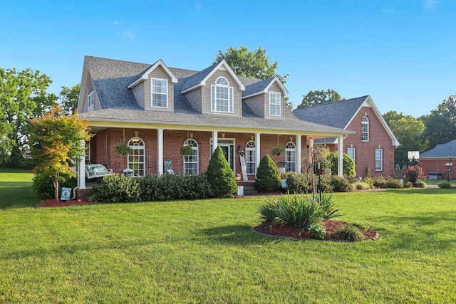 cape cod home featuring a porch and a front yard