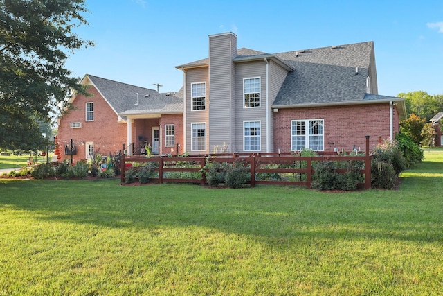 rear view of property with a lawn