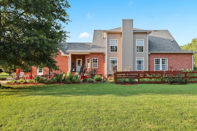 rear view of house featuring a lawn