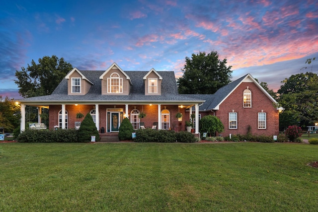 view of front of property with a porch and a yard