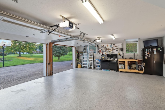 garage with a yard, a garage door opener, and a workshop area