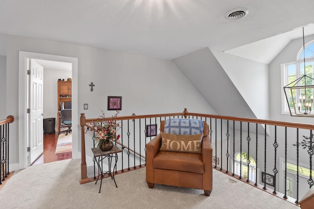 sitting room with light carpet, a notable chandelier, and vaulted ceiling