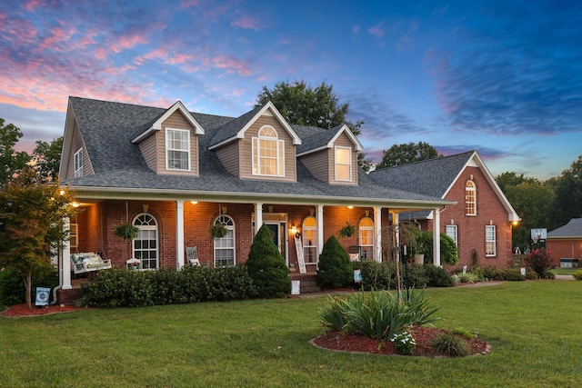 new england style home with a yard and covered porch