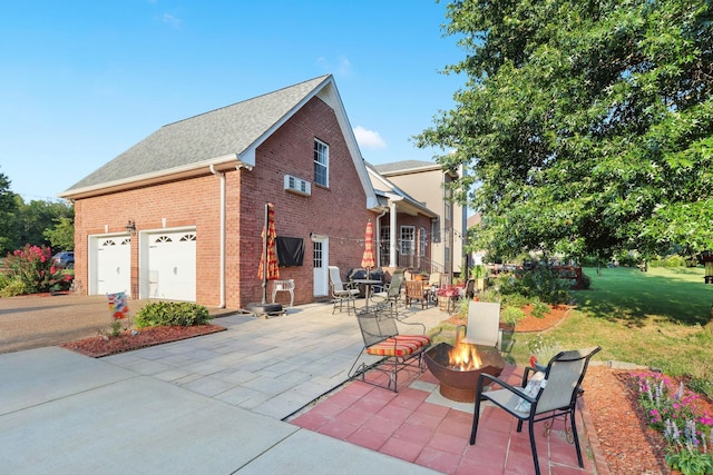 view of property exterior with a garage, a patio, and an outdoor fire pit