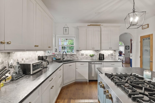 kitchen featuring dishwasher, white cabinetry, sink, hanging light fixtures, and dark wood-type flooring