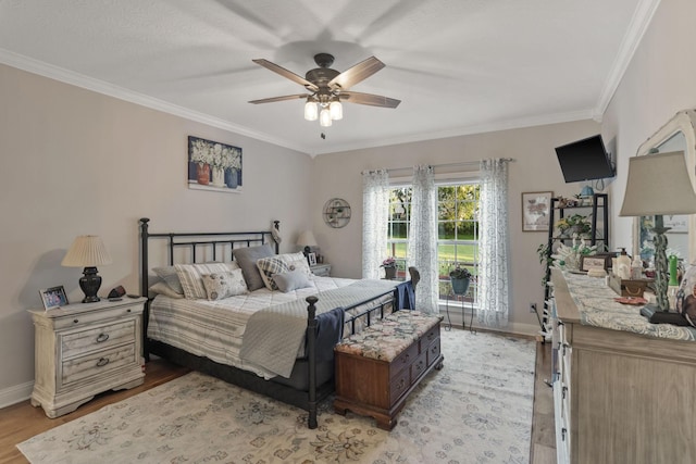 bedroom with ornamental molding, light wood-type flooring, and ceiling fan