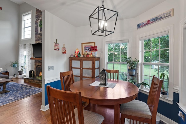 dining room featuring a fireplace, dark hardwood / wood-style flooring, and a notable chandelier