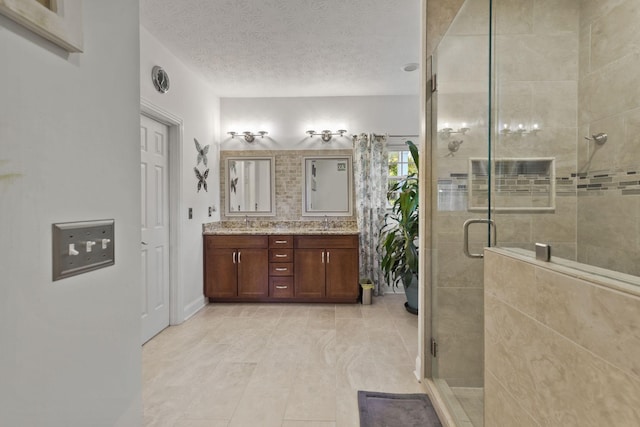 bathroom with vanity, tile patterned floors, a textured ceiling, and walk in shower