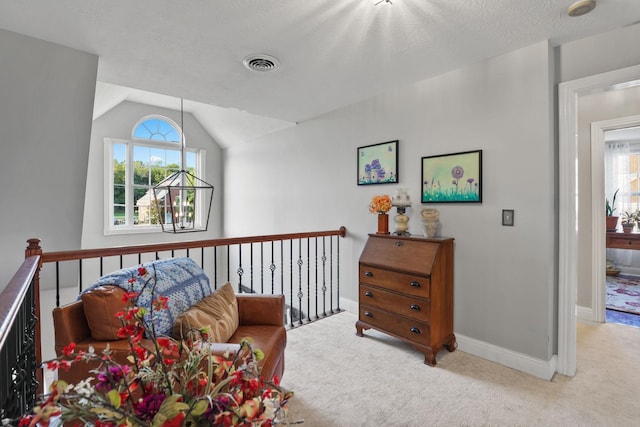 sitting room with light colored carpet, lofted ceiling, a textured ceiling, and a notable chandelier