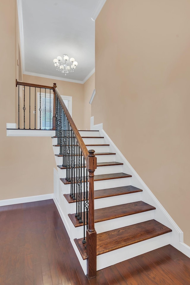 stairs featuring an inviting chandelier, crown molding, and hardwood / wood-style flooring