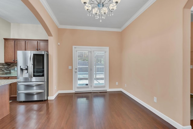 kitchen featuring dark hardwood / wood-style flooring, backsplash, stainless steel fridge, and ornamental molding