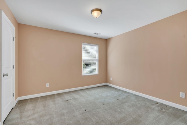 spare room featuring light colored carpet