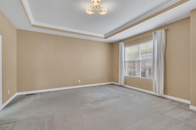 empty room with a raised ceiling, crown molding, light carpet, and a notable chandelier