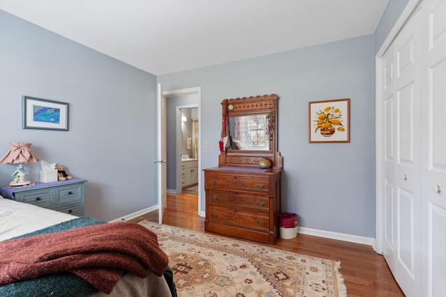 bedroom with a closet, wood finished floors, and baseboards