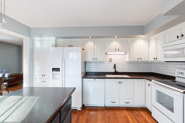 kitchen with dark wood-type flooring, sink, white cabinetry, tasteful backsplash, and white appliances