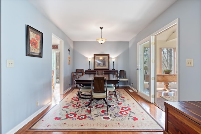 dining area featuring baseboards and light wood-style floors