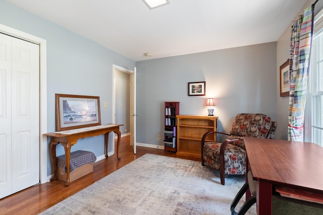 sitting room with baseboards and wood finished floors