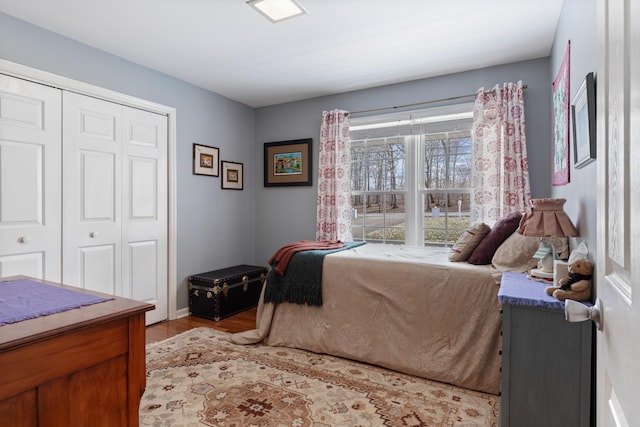 bedroom with a closet, baseboards, and light wood finished floors