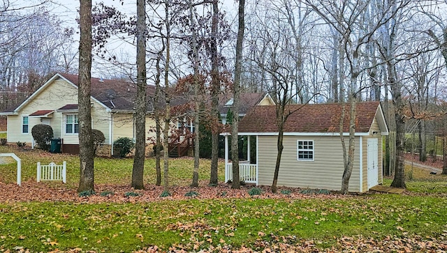 view of front of property with a storage shed, a front lawn, and an outbuilding