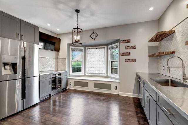 kitchen with sink, gray cabinetry, stainless steel appliances, tasteful backsplash, and beverage cooler