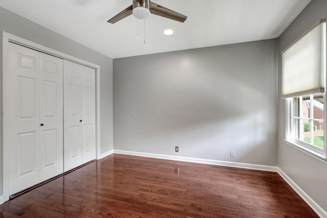 unfurnished bedroom featuring dark hardwood / wood-style floors, ceiling fan, and a closet