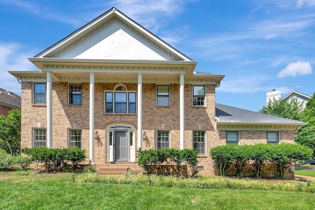 greek revival house featuring a front lawn