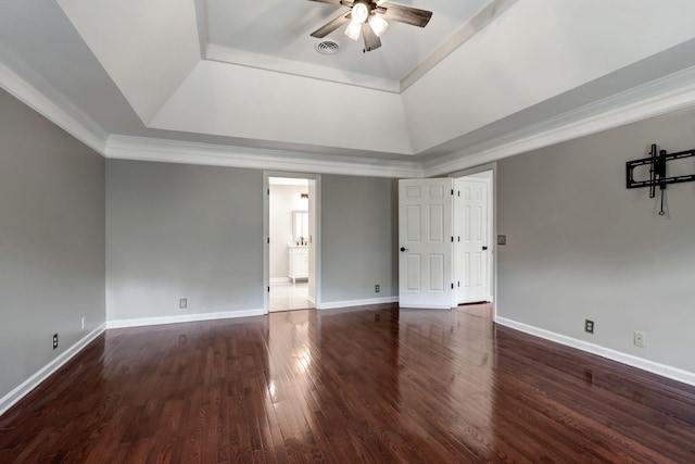 unfurnished bedroom featuring ornamental molding, dark hardwood / wood-style floors, ceiling fan, and a tray ceiling