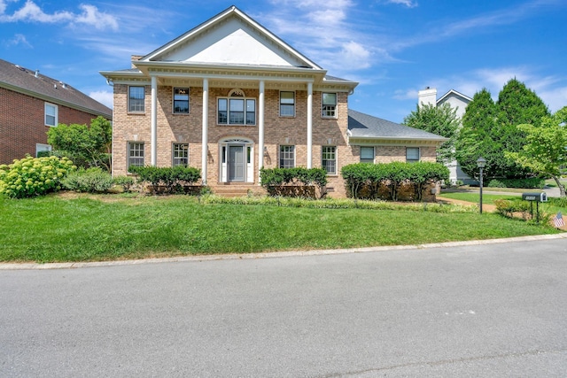 greek revival house featuring a front lawn