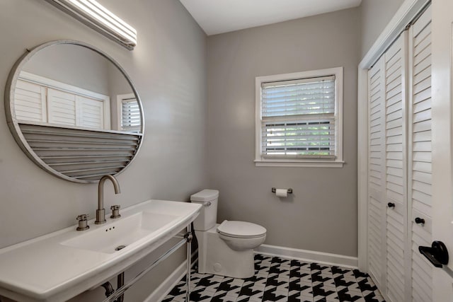 bathroom featuring sink, toilet, and tile patterned flooring