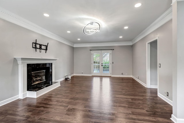 unfurnished living room with a premium fireplace, dark hardwood / wood-style floors, ornamental molding, and french doors