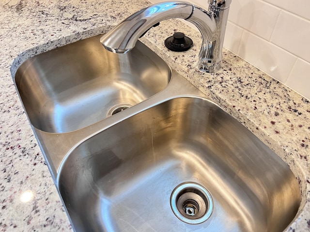 room details featuring light stone counters and sink