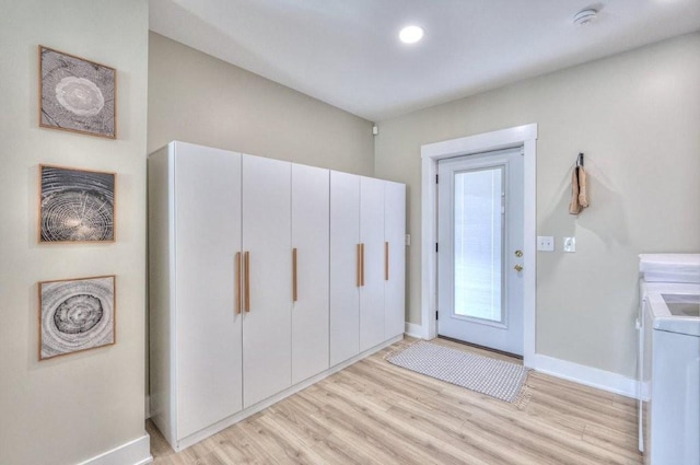 interior space with washer and clothes dryer and light hardwood / wood-style flooring