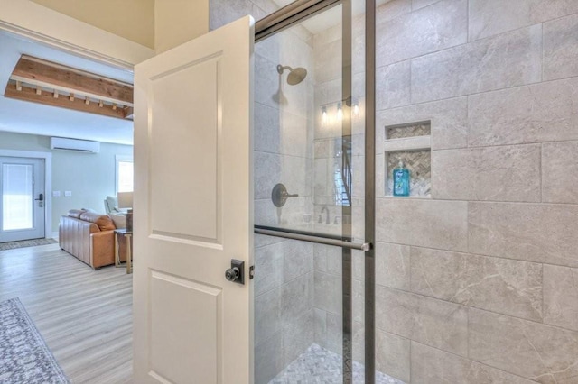 bathroom with hardwood / wood-style flooring, a wall mounted air conditioner, and an enclosed shower