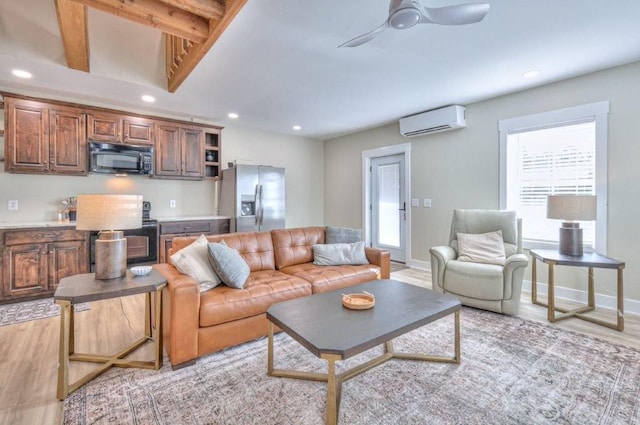 living room with a wall mounted air conditioner, beamed ceiling, ceiling fan, and light wood-type flooring