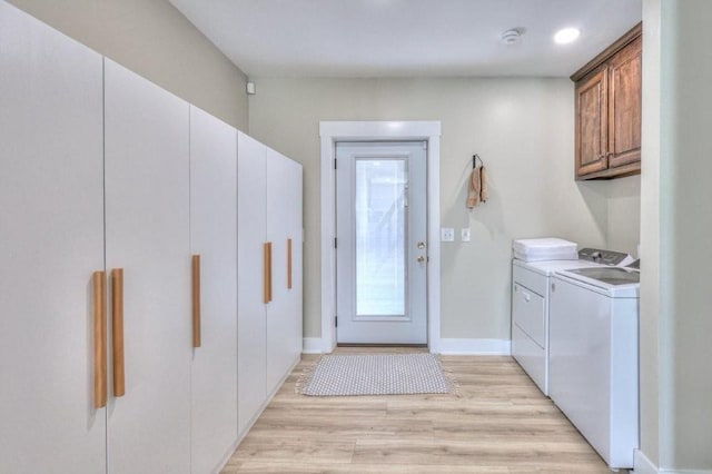 laundry room with washer and clothes dryer and light hardwood / wood-style flooring