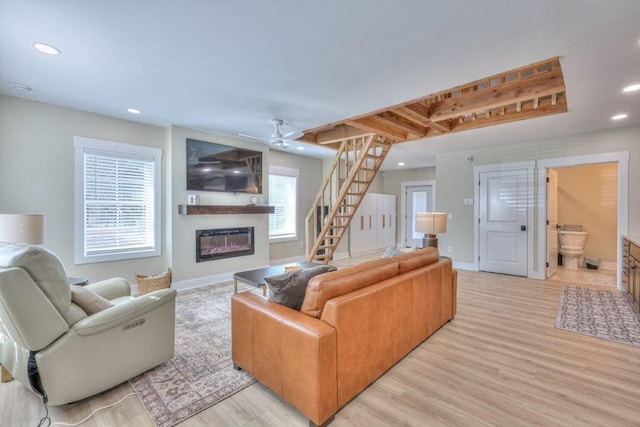 living room with ceiling fan and light hardwood / wood-style flooring